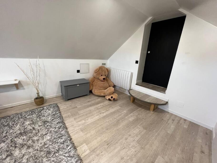 a teddy bear sitting in the corner of a room at Maison cocooning Porcheville 