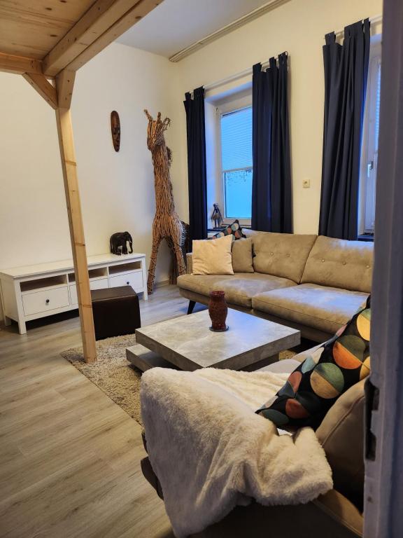 uma sala de estar com um sofá e uma estátua de girafa em Ferienhaus Susanne em Heinsberg
