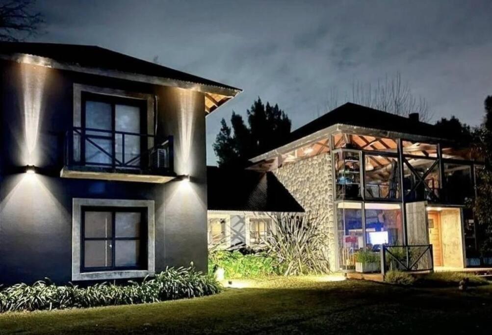 une maison éclairée la nuit dans l'établissement Exclusiva Casa en Country Club de Pilar con piscina climatizada 1500m2, à Buenos Aires
