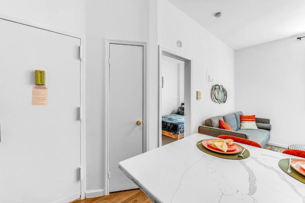 a white living room with a table with a plate of fruit on it at Welcome to “Sunny Park Slope Retreat”! in Brooklyn