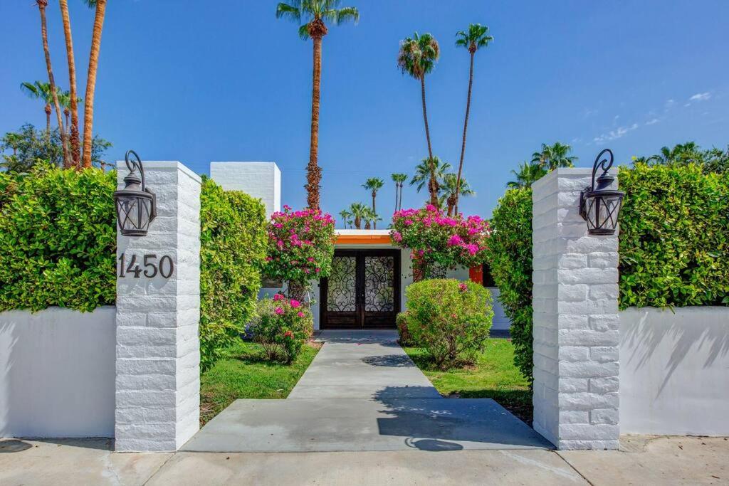 a walkway leading to a house with palm trees at Close to downtown PS - Hike, Bike, Swim, Relax in Palm Springs