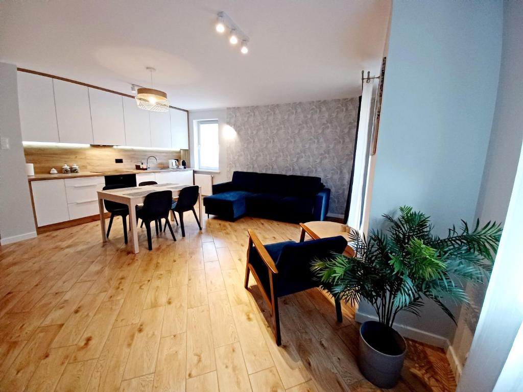 a living room with a couch and a table and chairs at Kolory Warmii Apartament Niebieski in Olsztyn