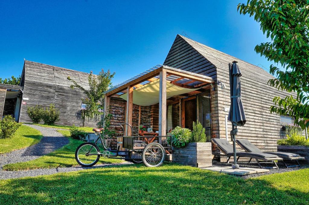 une maison avec un vélo garé dans la cour dans l'établissement Hišice Čarna - Houses Čarna, à Puconci