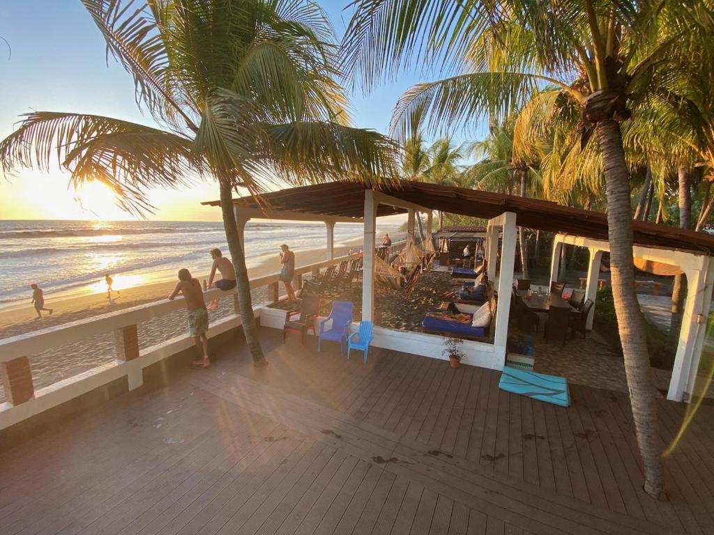 a view of a beach with palm trees and people at SOLID Surf Camp Hostel Nicaragua in Transito