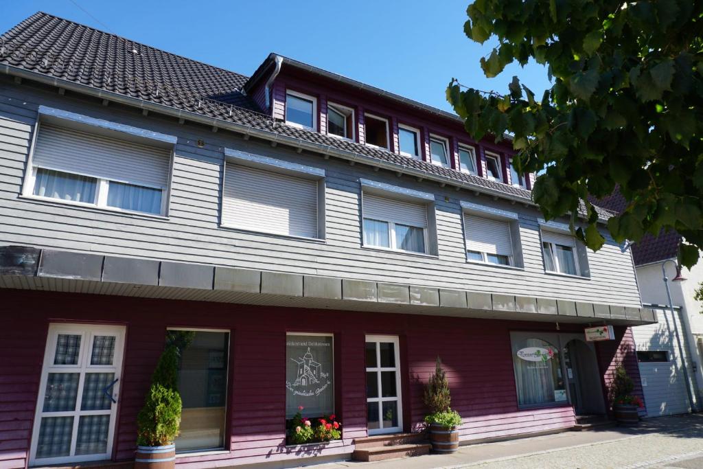 a red and white building with windows and plants at Pension-zur-Rose in Schönaich