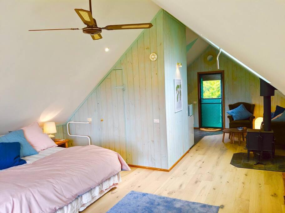 a bedroom with a bed and a ceiling fan at Alyeska Loft - Apollo Bay studio loft apartment in Apollo Bay