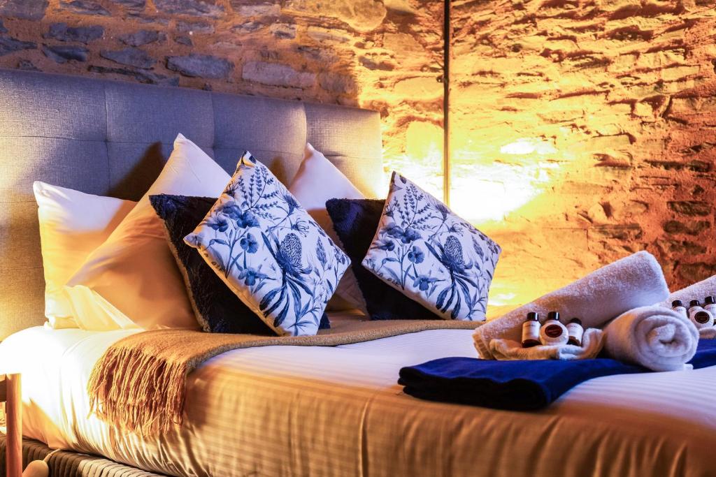 a bedroom with a bed with blue and white pillows at Reillys Wines Heritage Cottages in Mintaro