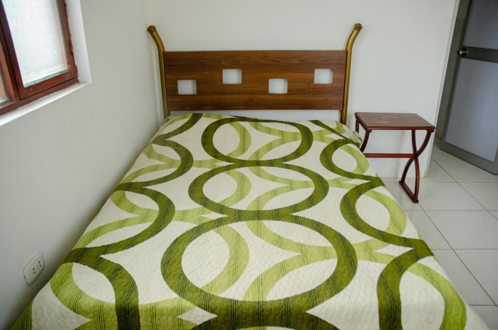 a bedroom with a bed with a green and white blanket at Ugarte Street in Trujillo