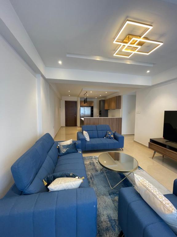 un soggiorno con divano blu e tavolo di Solaris Appartment 5&7th floor a Accra