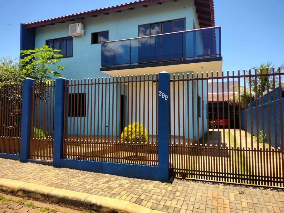 a blue fence in front of a house at Acomodação Três Fronteiras Foz in Foz do Iguaçu