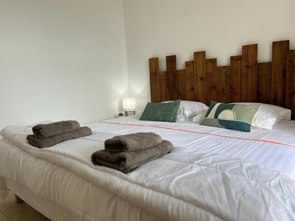 ein Schlafzimmer mit einem großen Bett mit Handtüchern darauf in der Unterkunft Ruddy’s house in Le Gosier