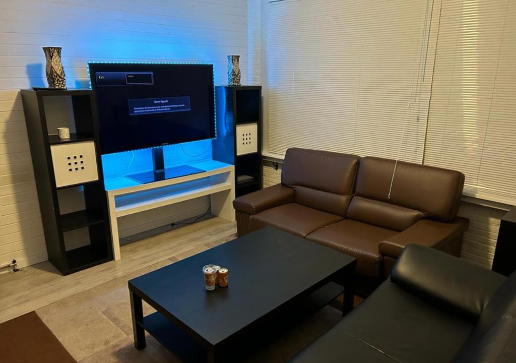 a living room with a couch and a tv at Nice house in Rotterdam