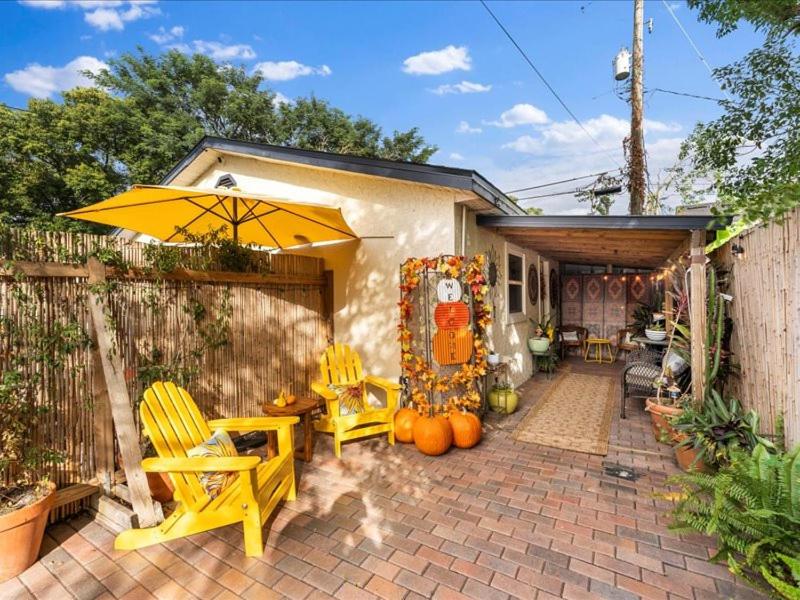 eine Terrasse mit gelben Stühlen und einem Sonnenschirm in der Unterkunft College Park-Orlando 5Star Oasis - QUIET Neighborhood-PRIVATE-Free Parking-mins from EOLA,DT, Winter Park in Orlando