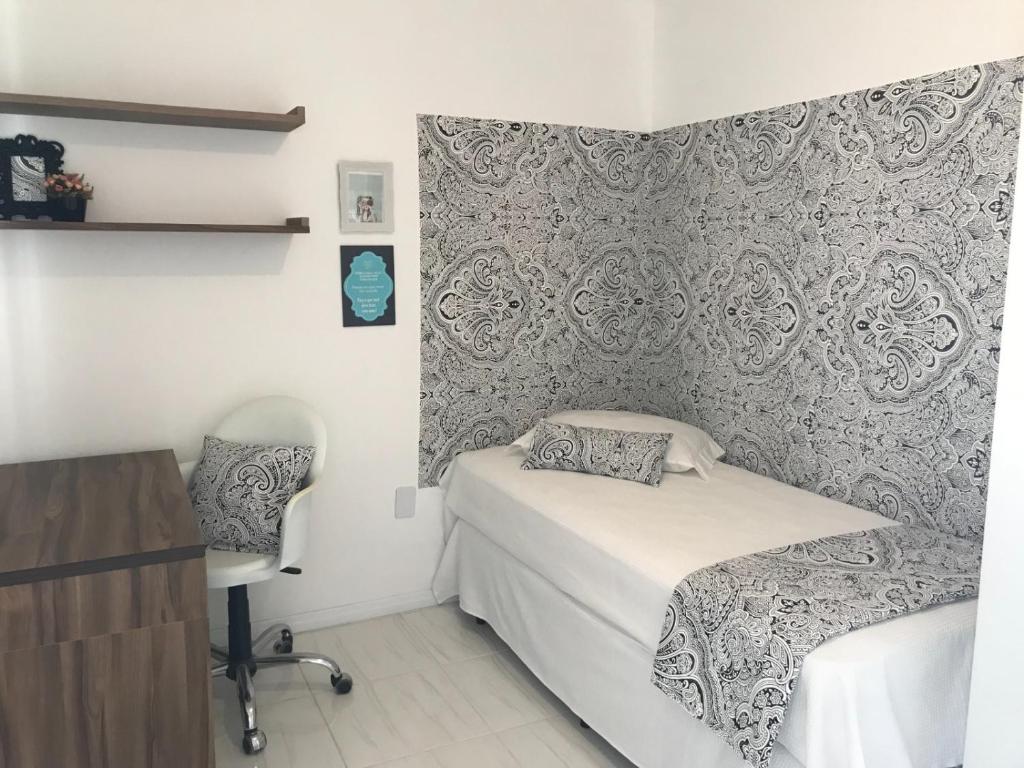 a small bedroom with a bed and a chair at República Descolada! Exclusiva para mulheres! in Florianópolis