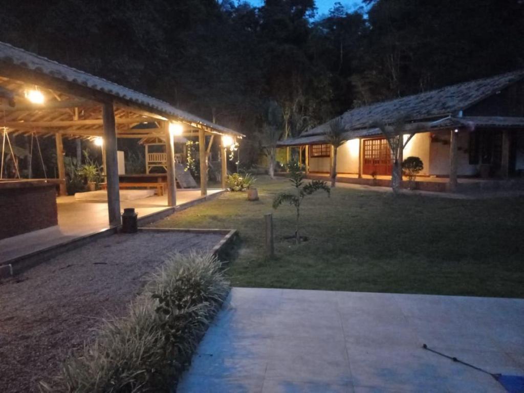 une maison avec une cour éclairée la nuit dans l'établissement Sítio Vale da Cachoeira, à Pôrto Firme