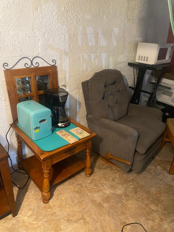 a living room with a chair and a table with a machine at Entire space in Syracuse