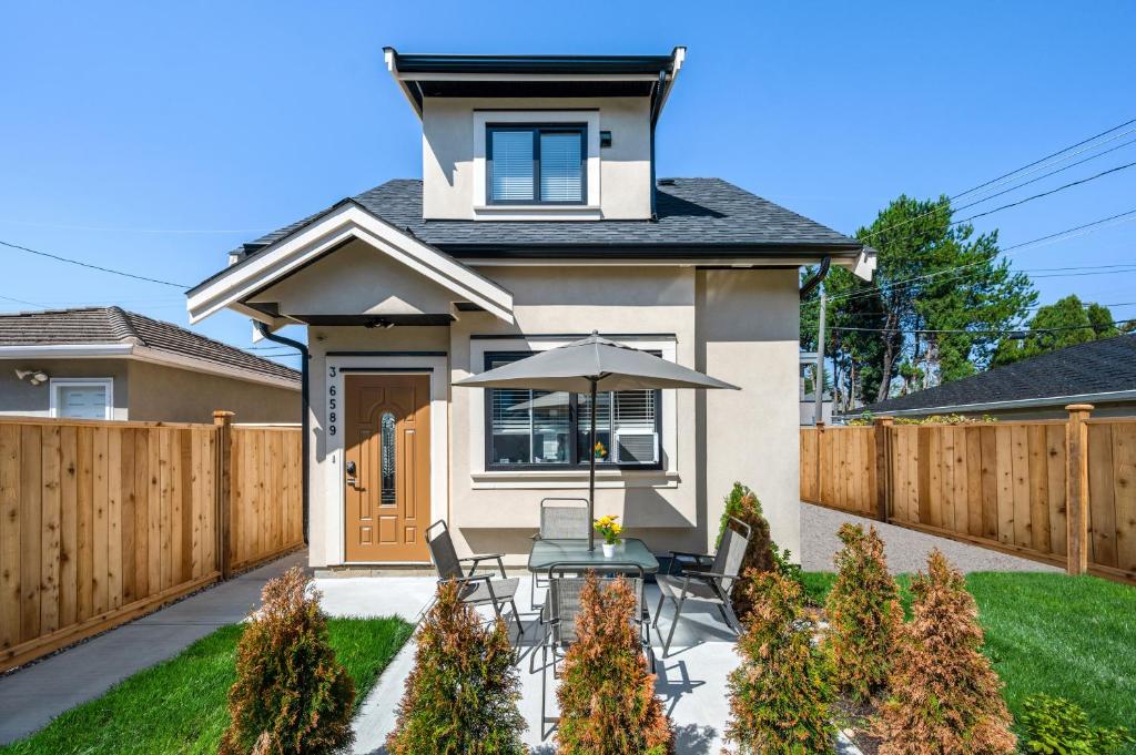 einen Hinterhof mit einem Tisch und einem Sonnenschirm in der Unterkunft Three bedrooms brand new laneway house near public transit in Vancouver