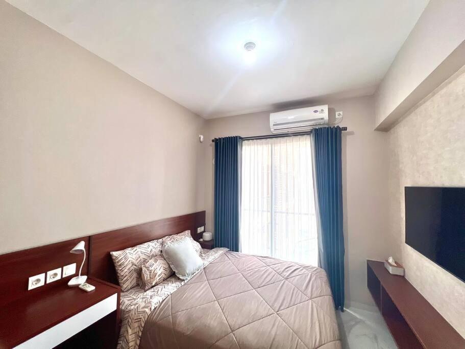 a bedroom with a bed and a large window at Livingatri - Skyhouse BSD next to AEON near ICE BSD in Cilandak