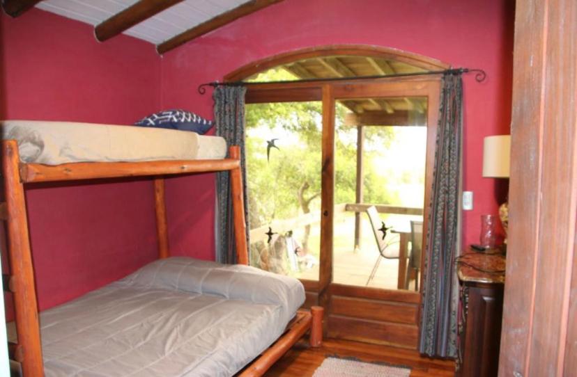 1 dormitorio con litera y ventana grande en Country Laguna El Rosario - Pinamar en Pinamar