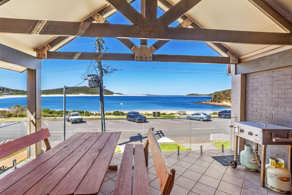 a picnic table on a patio with a view of the water at Beach Duplex 72 Marine Dr - Fingal Bay in Fingal Bay