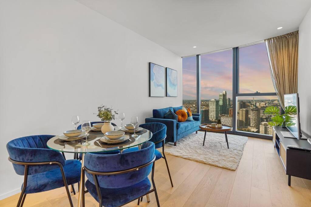 comedor con mesa y sillas azules en la sala de estar en Heart Of The Ocean- Bay & City Views 2B2B, en Melbourne
