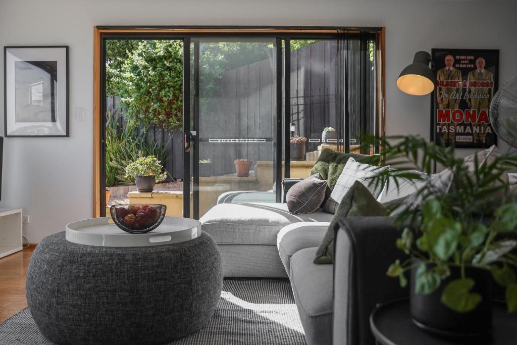 uma sala de estar com um sofá e uma mesa em Finnview House em Hobart