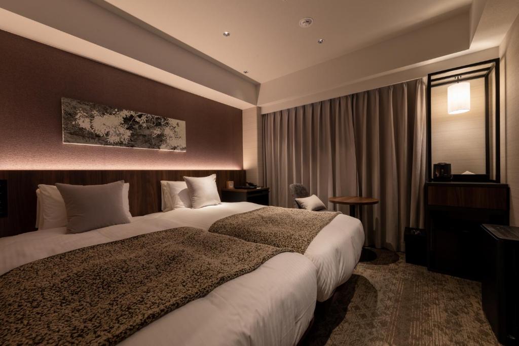a hotel room with two beds and a window at Iroha Grand Hotel Kintetsu Nara Ekimae in Nara