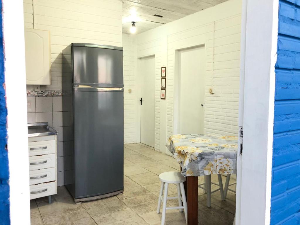 Il comprend une cuisine équipée d'un réfrigérateur et d'une table. dans l'établissement Hospedaria Mirante da maré ap4, à Imbituba