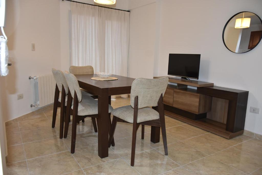 un tavolo da pranzo con sedie e una TV di Patagonia 55 a Neuquén