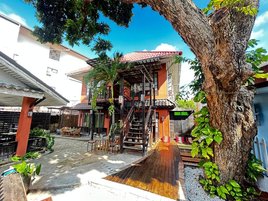 a house with a tree in front of it at Villa’s Homestay in Chiang Mai