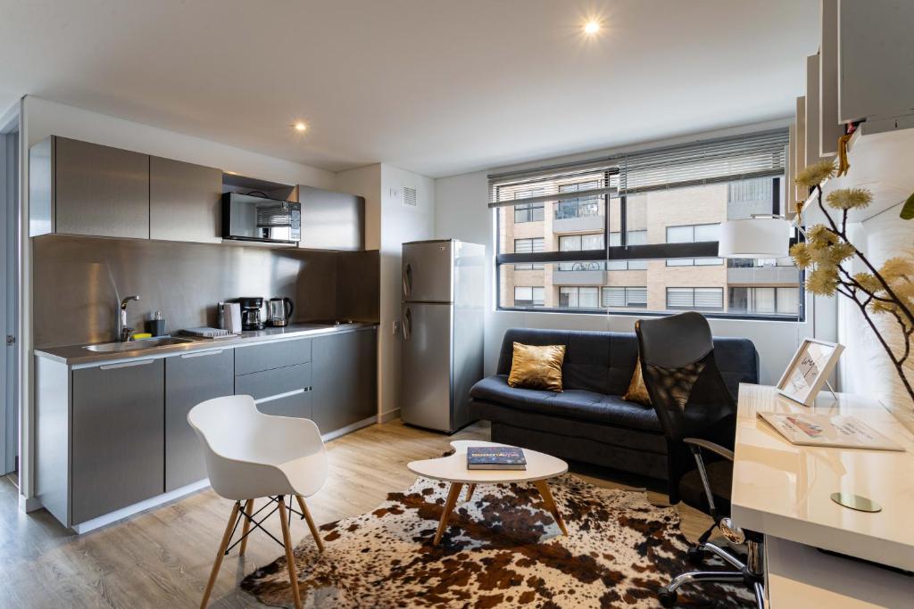 uma cozinha e sala de estar com um sofá e uma mesa em Loft nuevo, moderno, central em Bogotá