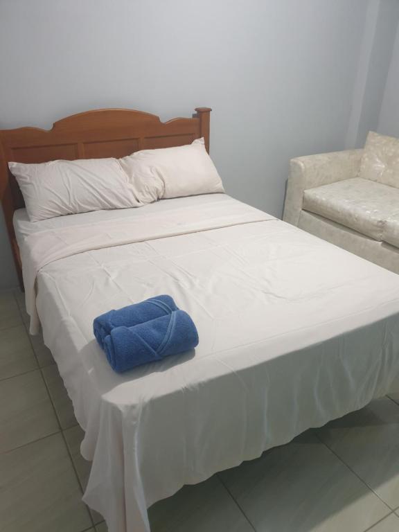 a bed with a blue towel on top of it at Rooftop Inn Apartments in Piarco