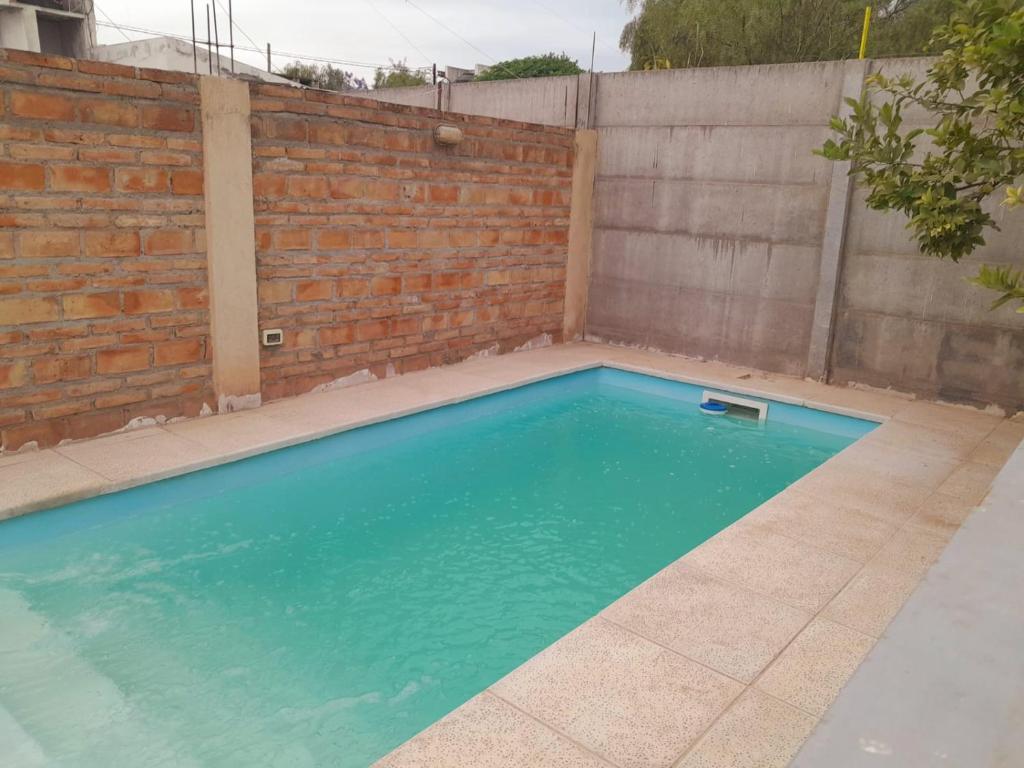 einen Pool vor einer Backsteinmauer in der Unterkunft El Bonsai in Santiago del Estero