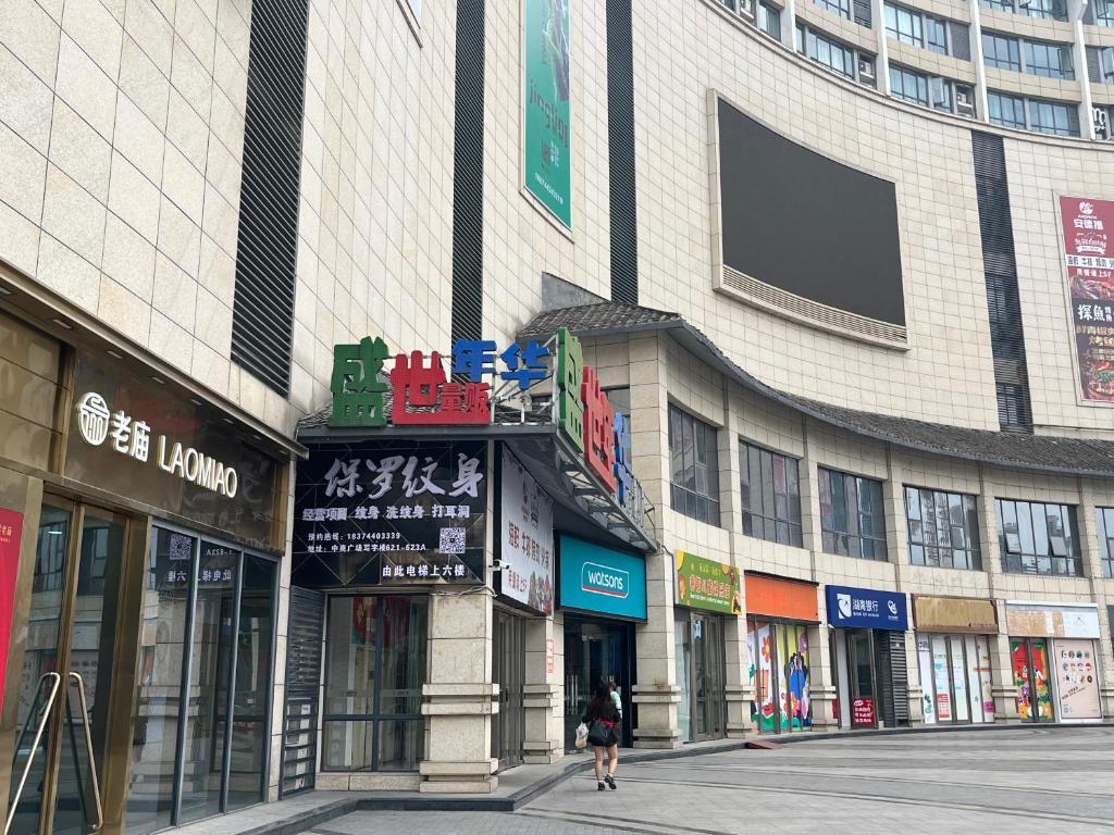 a woman walking down a street in front of a building at Zhangjiajie ViVi Boutique Hotel in Zhangjiajie
