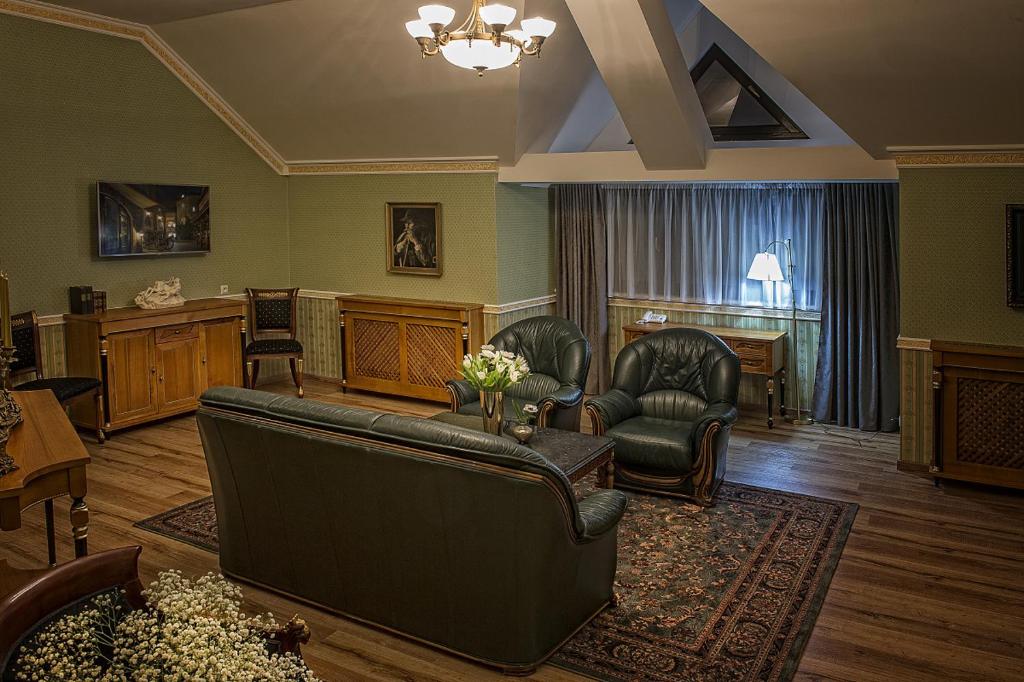 a living room with a couch and two chairs at Hotel Pod Bránou in Bardejov