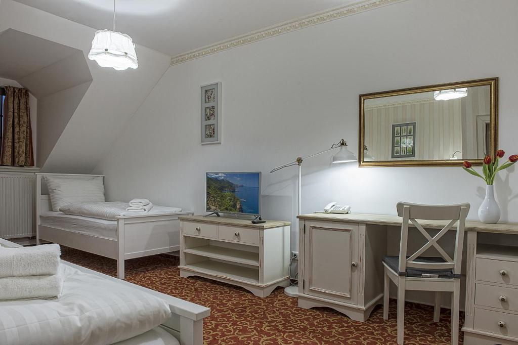 a bedroom with a desk and a bed and a mirror at Hotel Pod Bránou in Bardejov