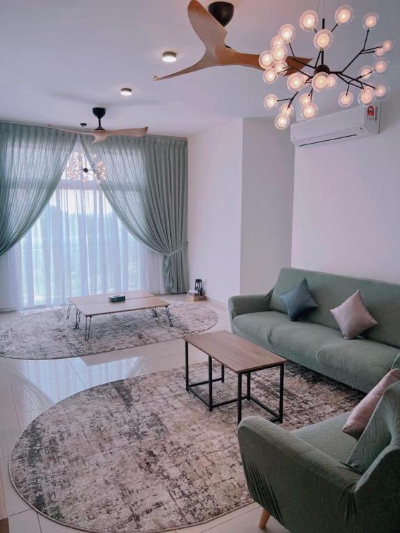a living room with a green couch and a ceiling fan at The Halt Putrajaya in Putrajaya