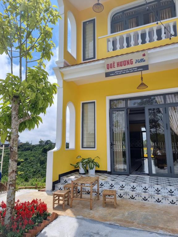 a yellow building with a table in front of it at Quê hương Villa (Indochine Villas Tam Chau) in Bao Loc