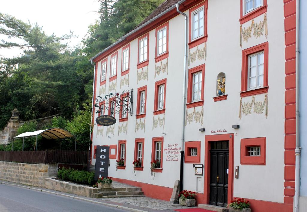 ein rot-weißes Gebäude an der Straßenseite in der Unterkunft Hotel Zum Goldenen Anker in Bamberg