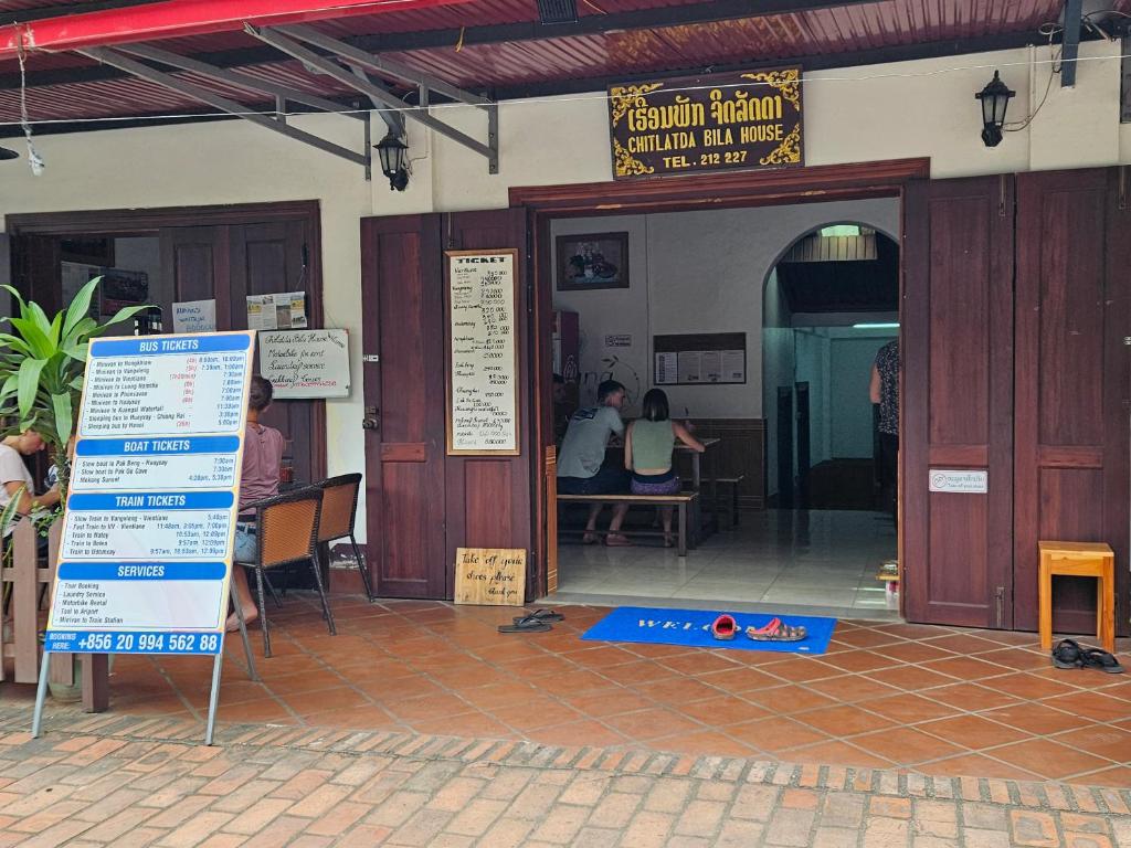 a restaurant with people sitting at tables in a building at Chitlatda Bila House in Luang Prabang