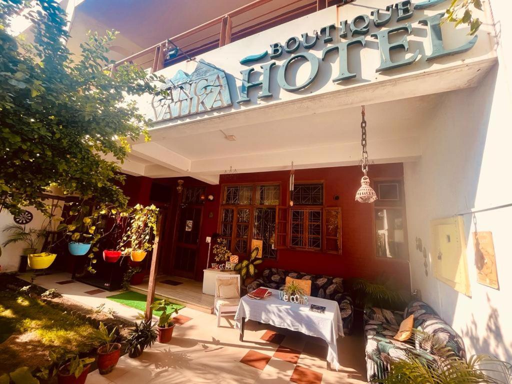 Ganga Vatika Boutique Hotel, Rishikesh في ريشيكيش: واجهة متجر امامه طاولة بيضاء