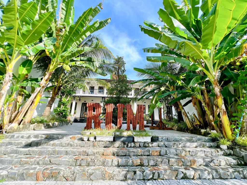 un gruppo di palme e scale di fronte a un edificio di Rum Resort a Phu Quoc