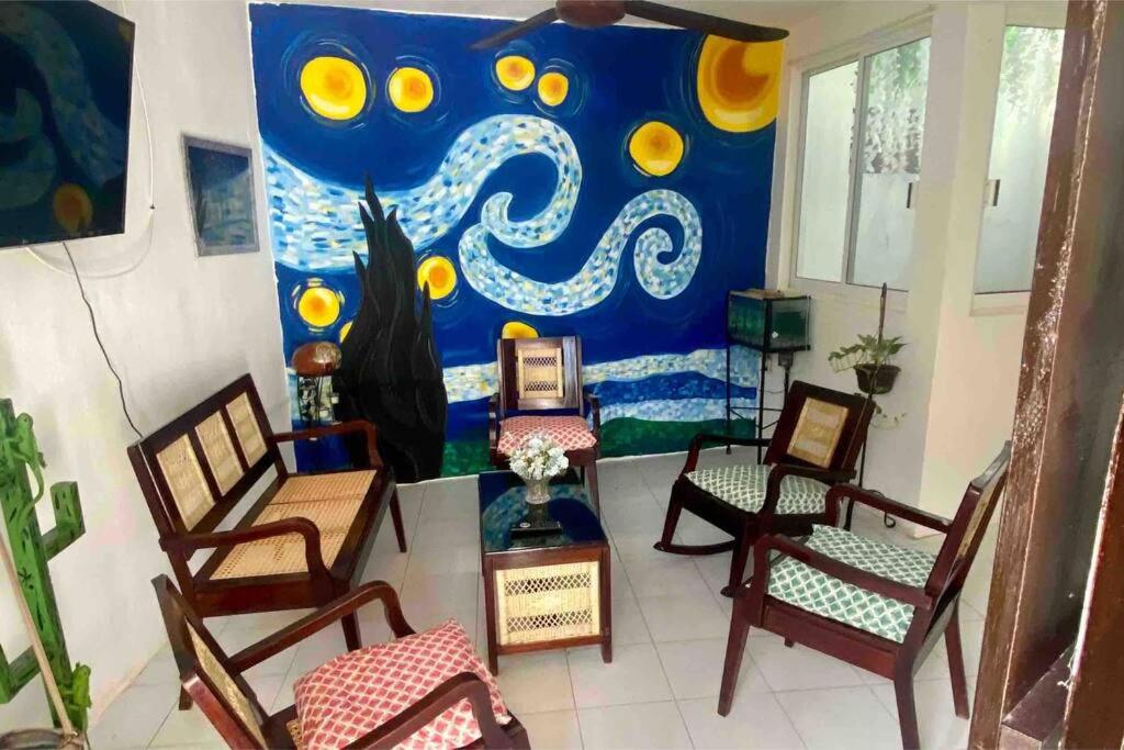 una habitación con sillas y una pintura en la pared en Casa 12 en Campeche