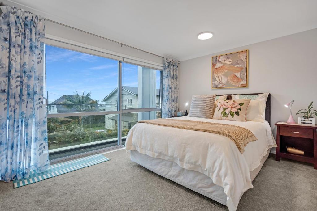 sypialnia z łóżkiem i dużym oknem w obiekcie The Bays Bed & Breakfast w Auckland