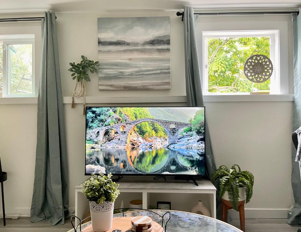 a television in a living room with two windows at Private studio near Green Lake/Lightrail/I-5 in Seattle
