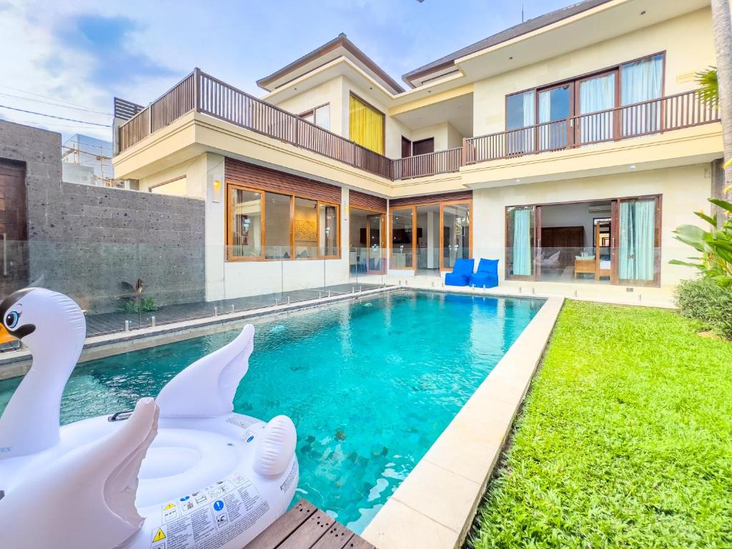 a house with a swimming pool with swans in the yard at Villa Echo Taman Bali in Canggu
