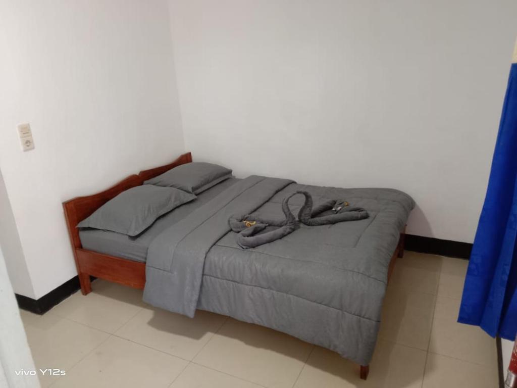 Una cama con dos pares de zapatillas. en BHELENA GUEST HOUSE, en Kelimutu