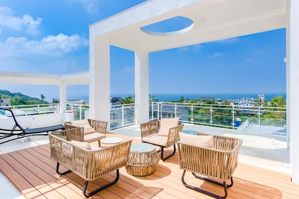 einen Balkon mit Stühlen und Meerblick in der Unterkunft 琉白包棟別墅 l 唱歌 l 麻將 in Xiaoliuqiu