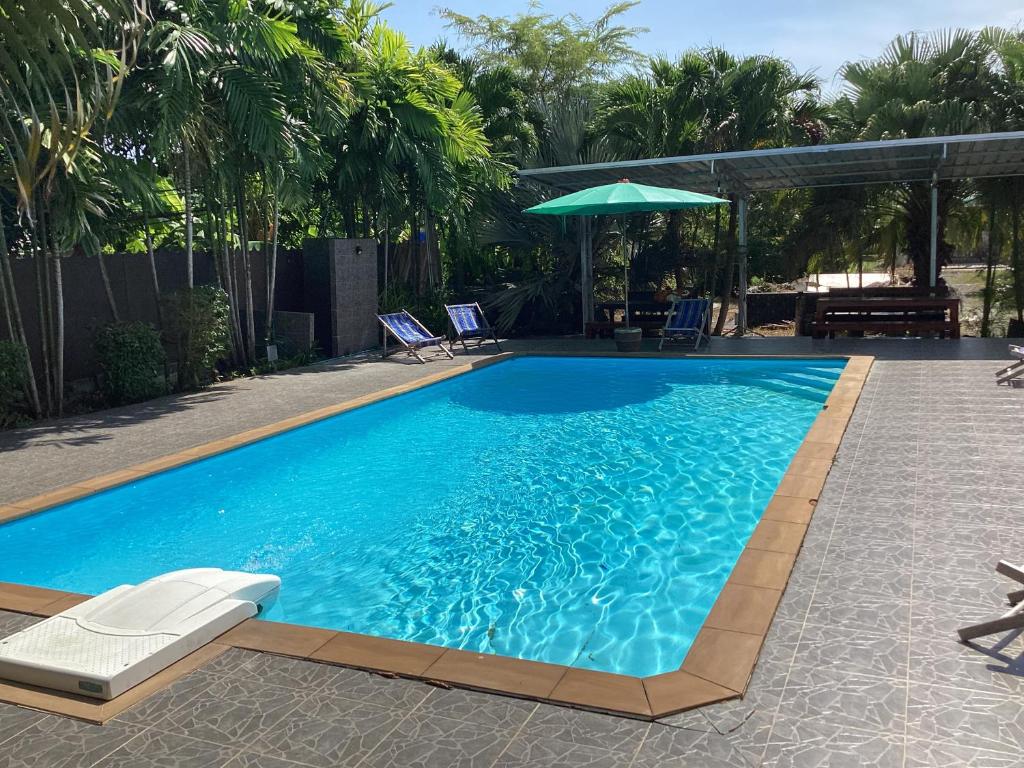 uma piscina com água azul num quintal em Oh taley resort em Rayong