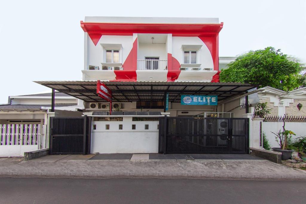 Uma casa branca com um portão à frente. em OYO 657 Elite Residence Central Park Mall By TOS em Jakarta